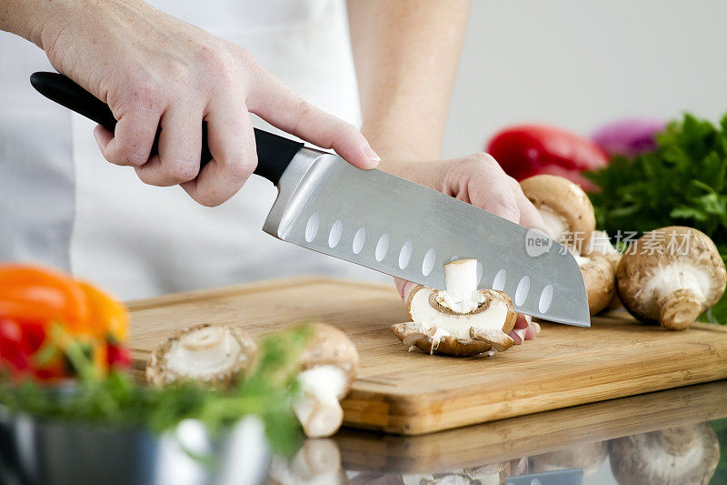 厨师用刀切蘑菇的选择性焦点