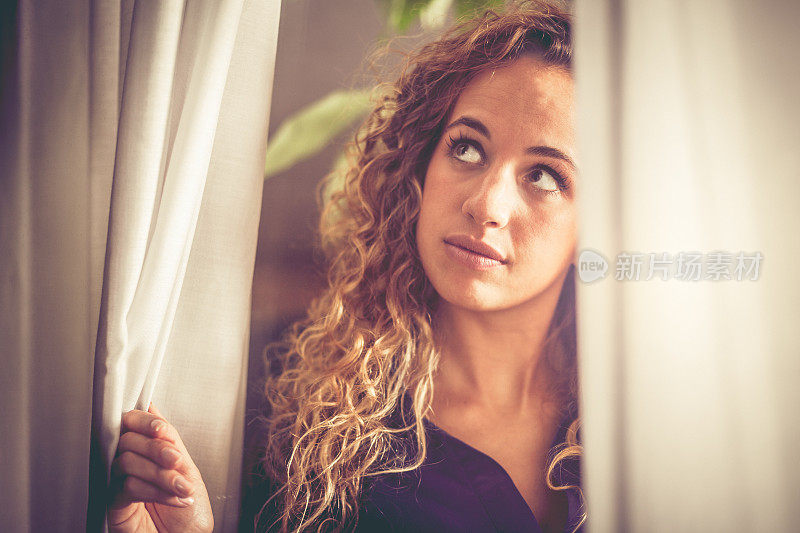 一个满怀希望的女人在窗边等待