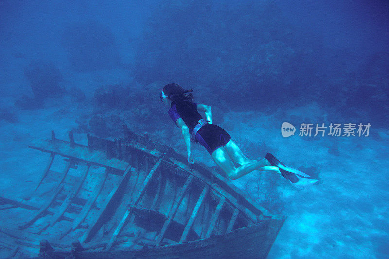 女人浮潜在部分船只残骸上