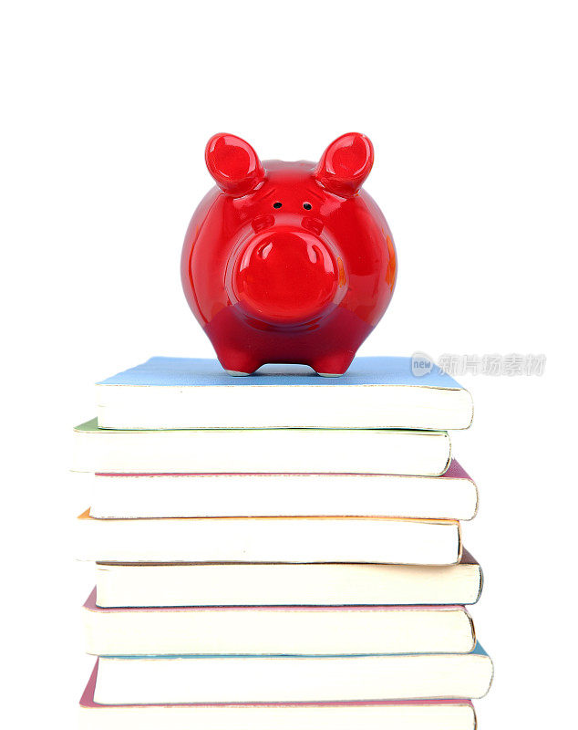 小猪储钱罐在一堆书上