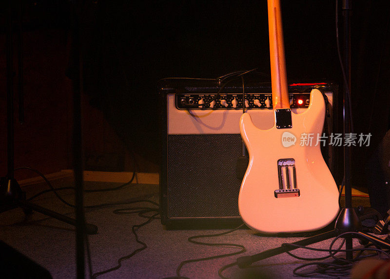 吉他和放大器在舞台上，黑暗的背景