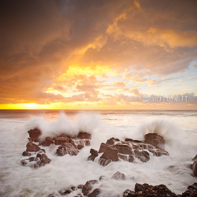 日出时海浪撞击岩石