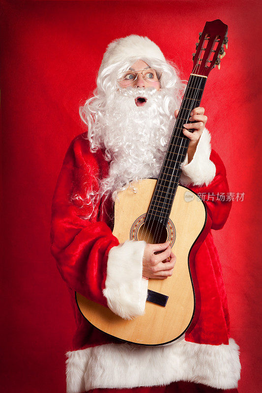 装扮成圣诞老人的人，弹吉他，唱歌