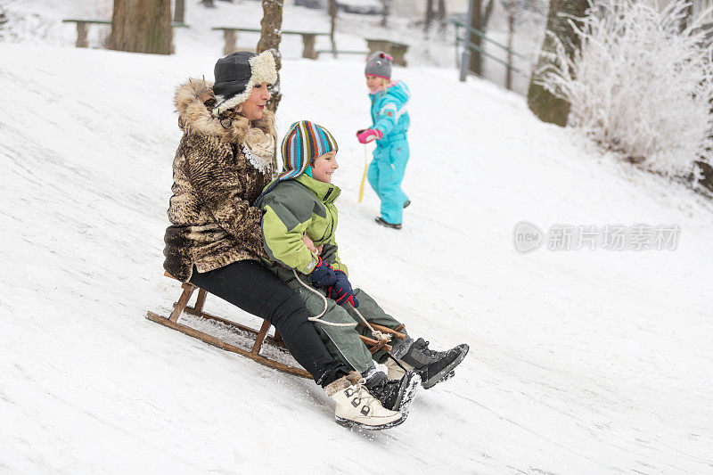 一个男孩和他的奶奶在雪橇上