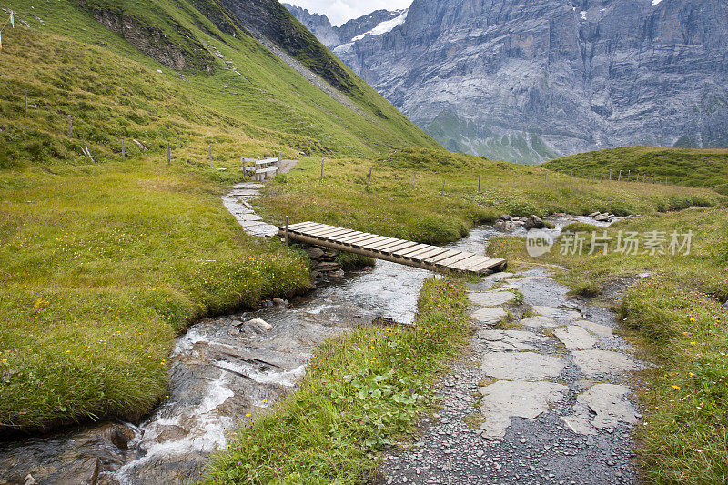 小桥横跨小溪，瑞士阿尔卑斯山