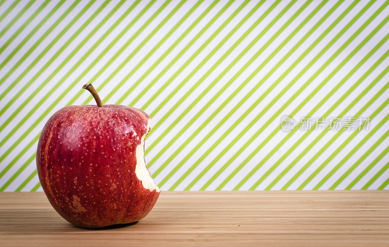红苹果在桌子上，绿色的背景和复制空间