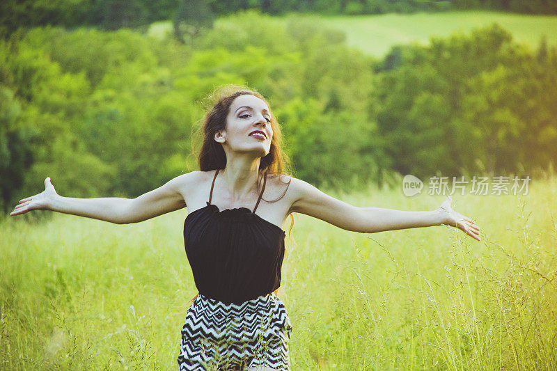 美丽的女人在草地做甩发