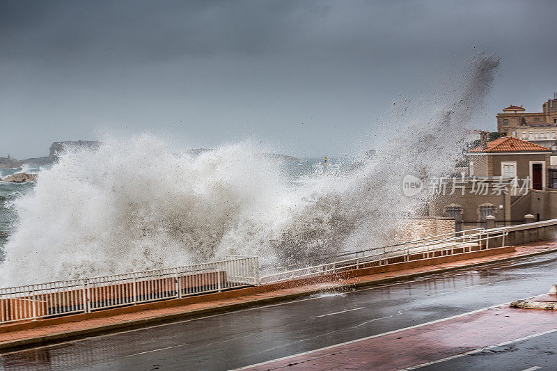 可怕的暴风雨背景与大海浪溅向城市道路