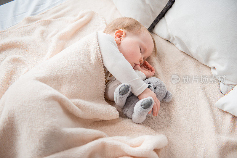 可爱的婴儿用玩具做梦