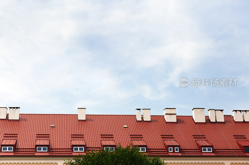 带有烟囱和阁楼的红色屋顶，天空背景，空间