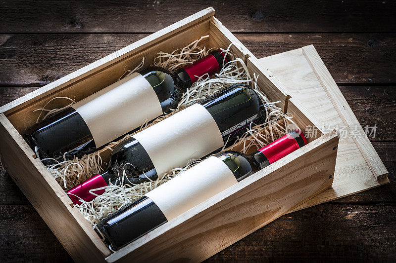 红酒瓶子装在一个木盒里，射在一张质朴的木桌上