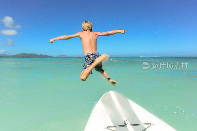 在夏威夷，7岁的小男孩从桨板上跳下来