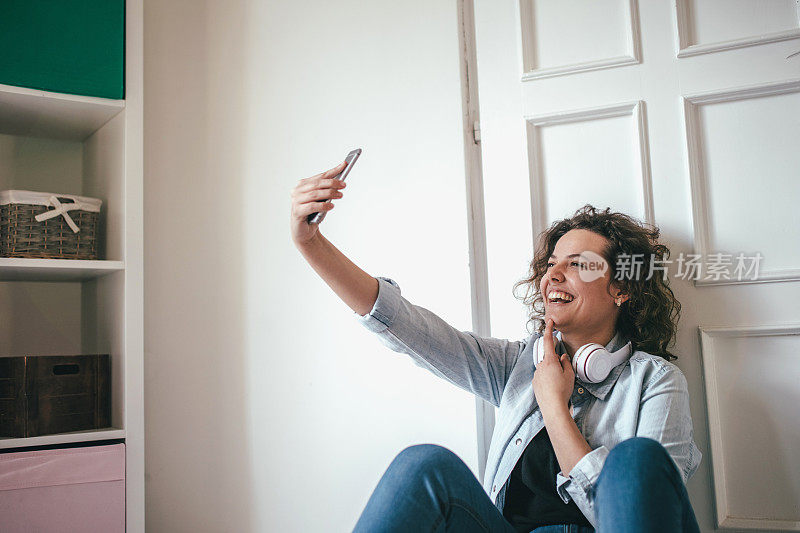 一个戴着耳机的年轻女人躺在地板上