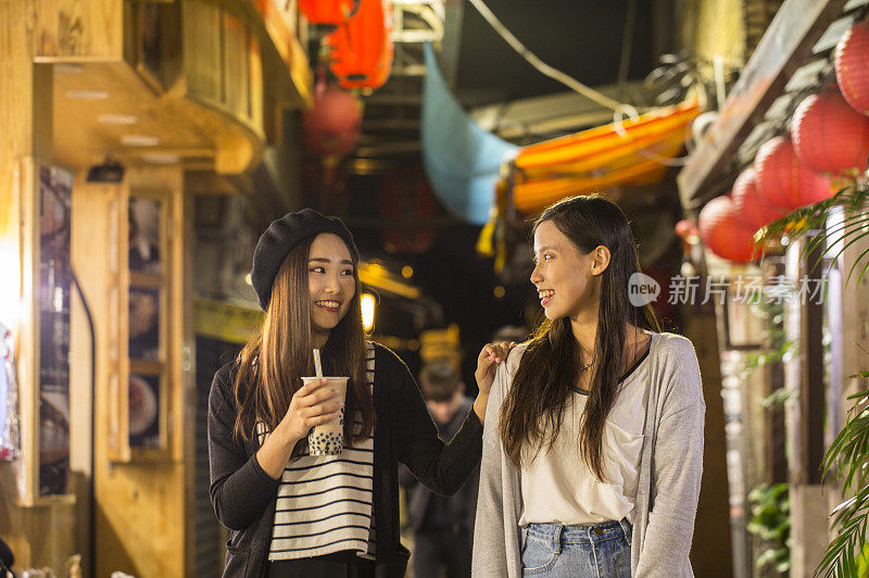 二位年轻女人在九份老街开心的聊天
