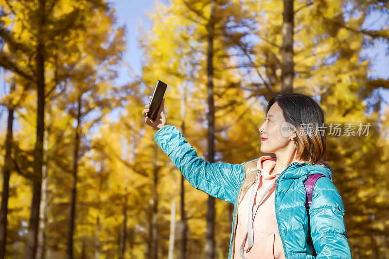 亚洲妇女旅行拍摄照片在森林