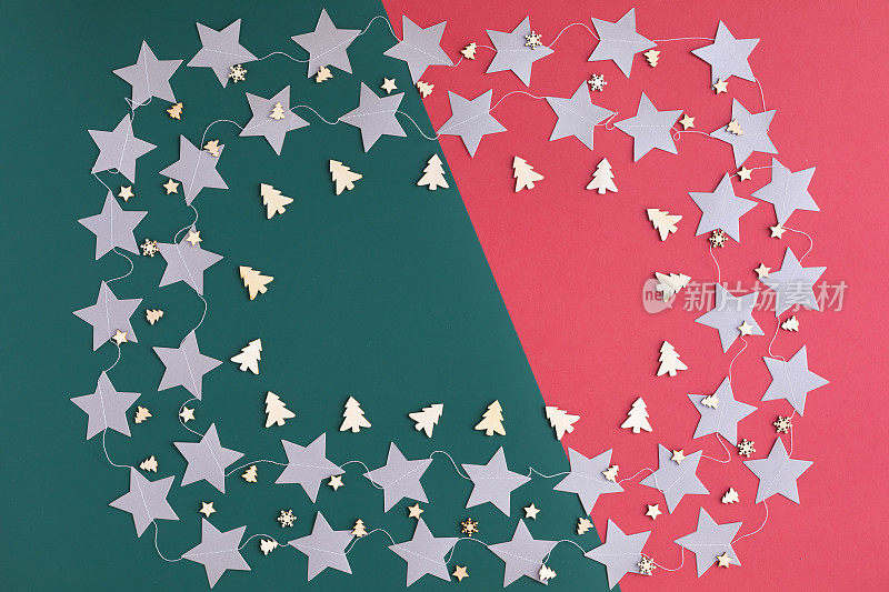 银星形状的圣诞纸花环框架在绿色和红色的背景。平躺，俯视图
