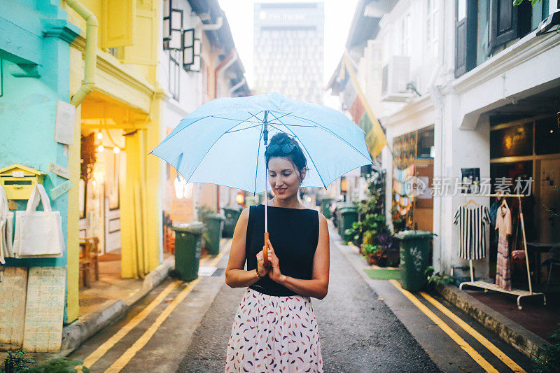 旅女在雨中探索新加坡的小巷子