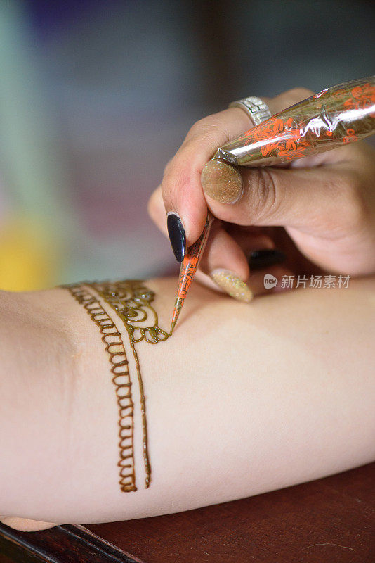 艺术家在手上绘制指甲花纹身
