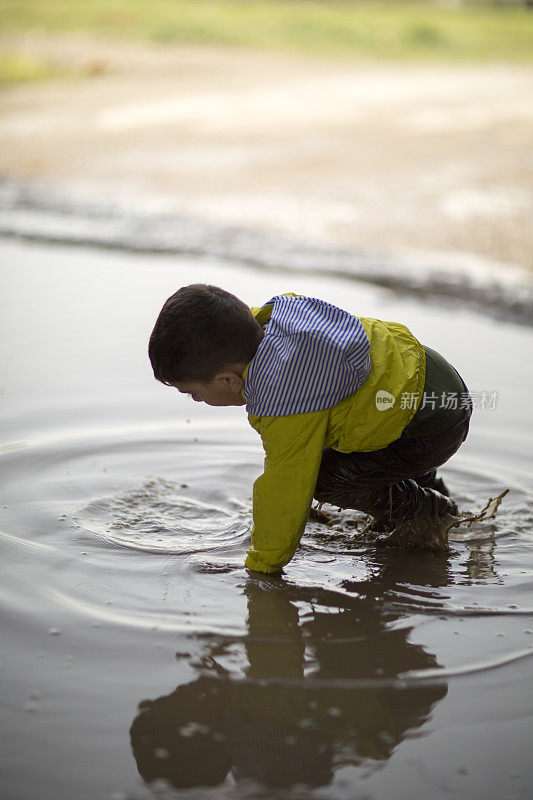 孩子们在雨坑里玩耍