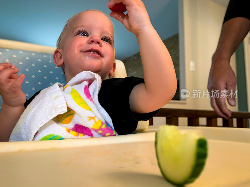 小男孩用手吃蔬菜。