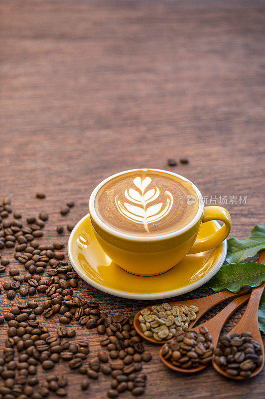 一杯含有漂亮拉花的拿铁咖啡和不同烘焙程度的咖啡豆