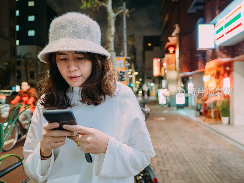 在日本，一个女人在户外发短信。