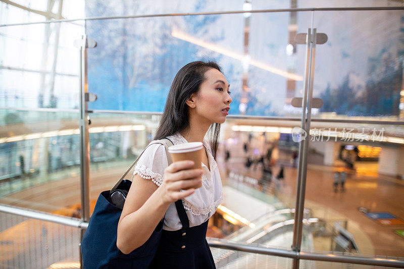 年轻的亚洲女人在机场候机楼里