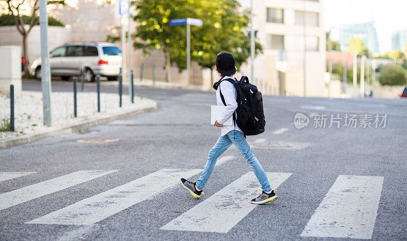 小学生背着背包过马路