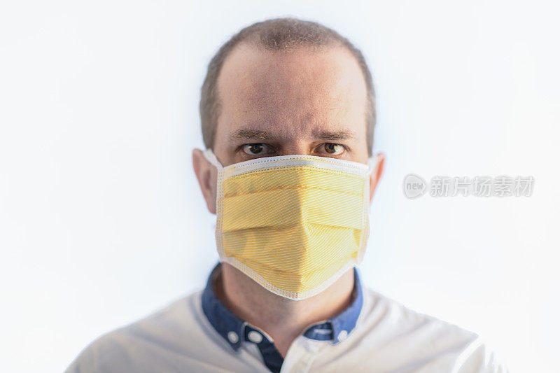男子戴医用防护口罩，以防止传播白色分离的冠状病毒