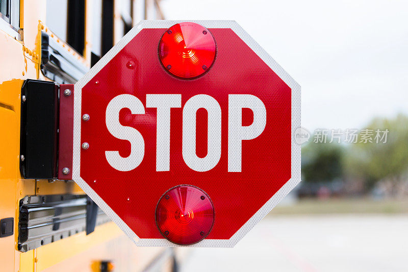 学校巴士的停车标志正在闪烁以警告司机