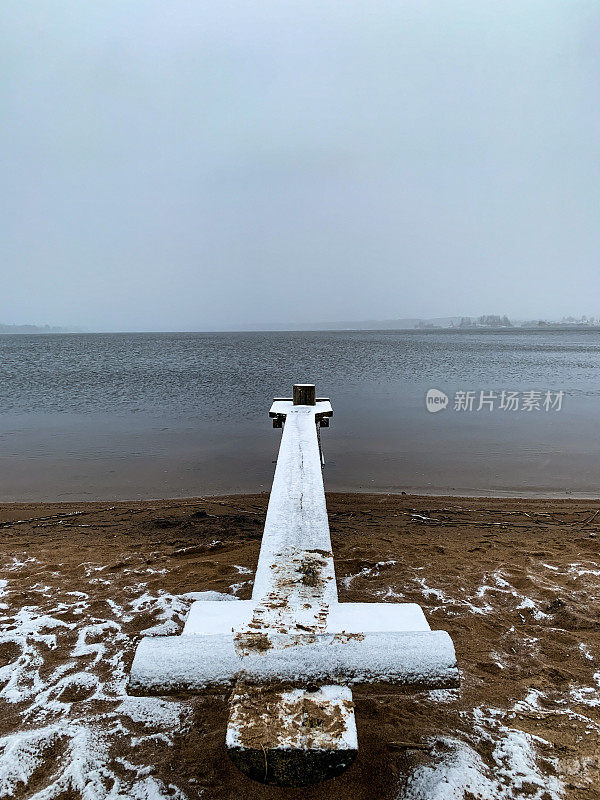 白雪覆盖的木墩。湖的景色。