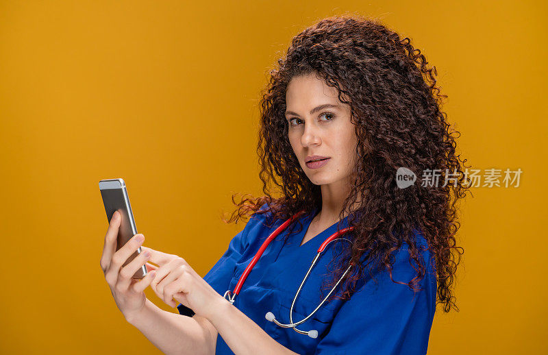 年轻女医生，带着智能手机，黄色背景