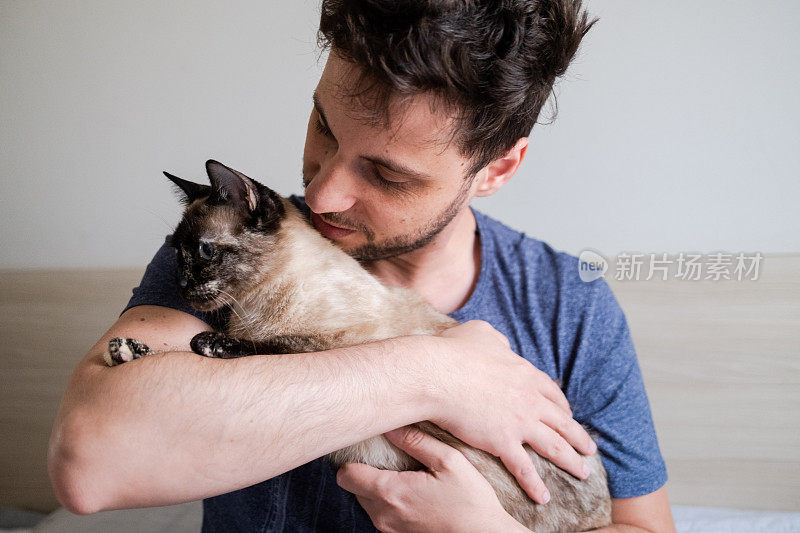 怀里抱着一只猫的男人