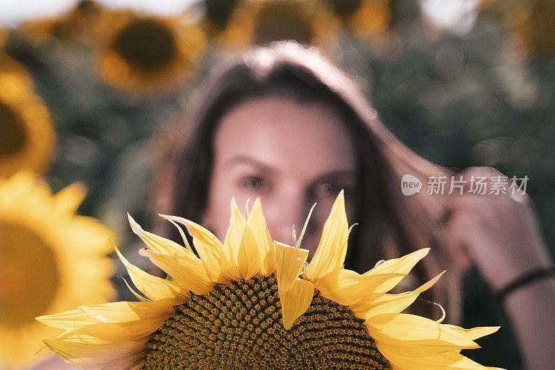 青少年的精神。向日葵的脸。一个年轻女孩的肖像在向日葵植物在夏天。旅行和享受。生态旅游。