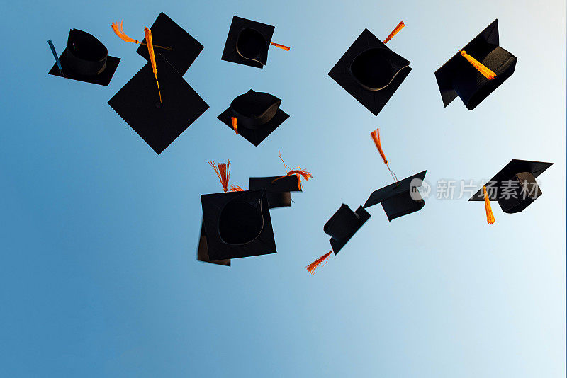 毕业生把黑帽子扔向天空。