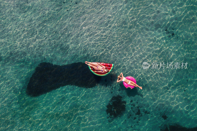 鸟瞰图的妇女漂浮在湖上与充气筏