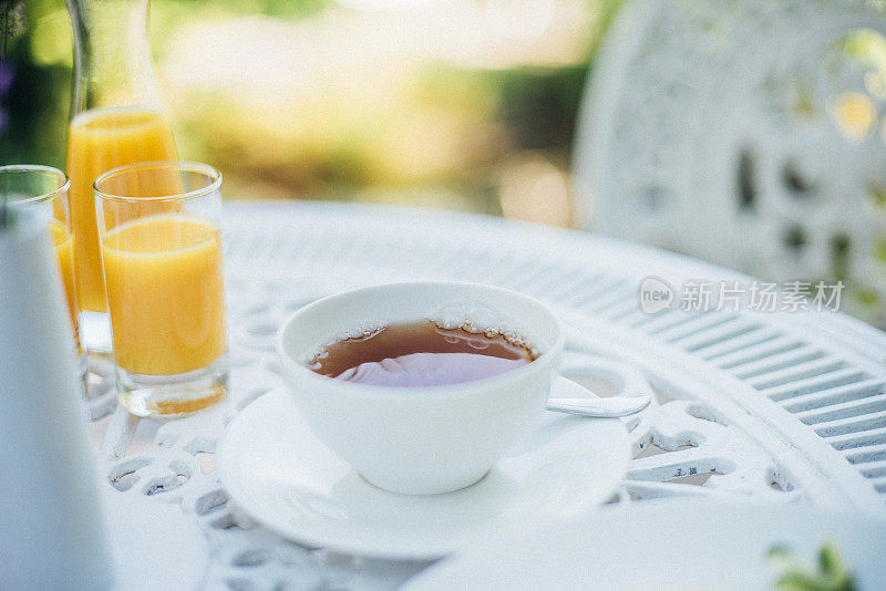 一杯茶放在花园的白色桌子上