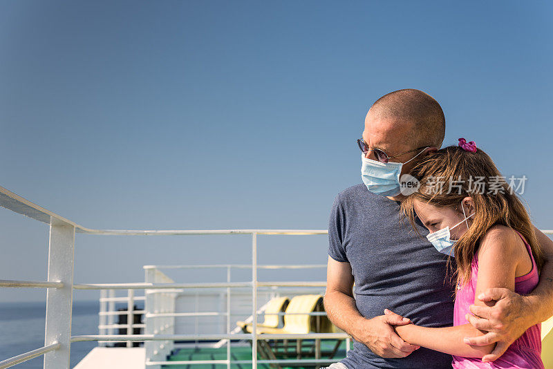 新冠肺炎疫情期间，父亲和女儿乘坐渡船，戴着面具坐在船甲板上