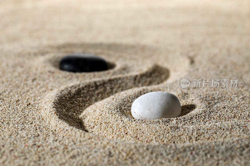 ,沙子上面放着黑白两块石头拼成的太极图案