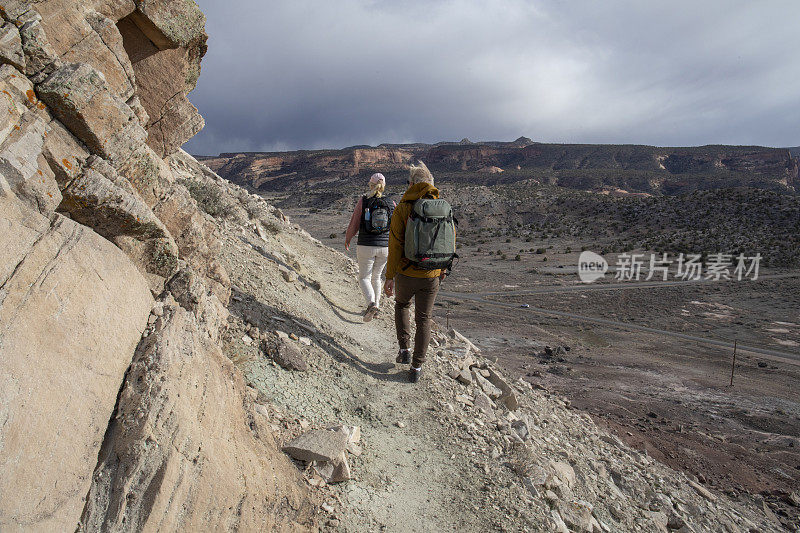 一对成熟的夫妇在早晨沿着阳光明媚的山脊徒步旅行