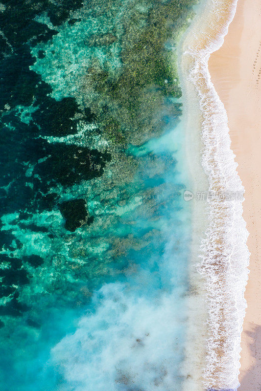 从上面的海滩场景-蓝色的海浪击中沙滩。