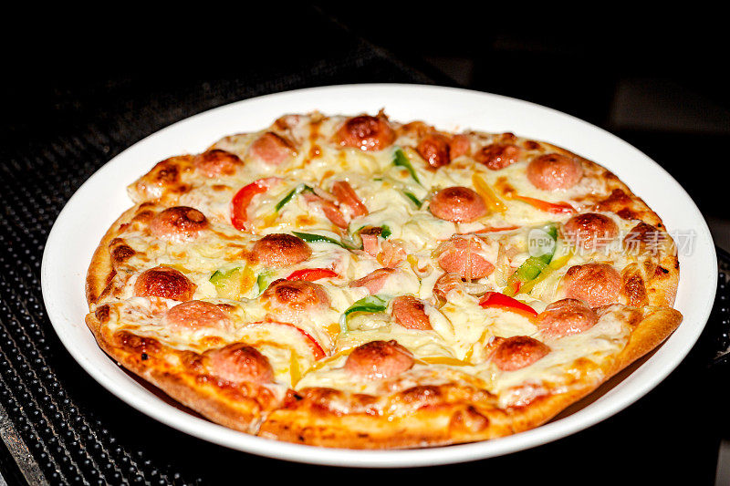 白盘子上的意大利香肠芝士披萨