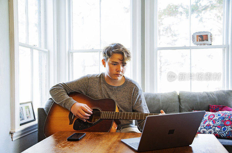 一个青少年正在网上上吉他音乐课