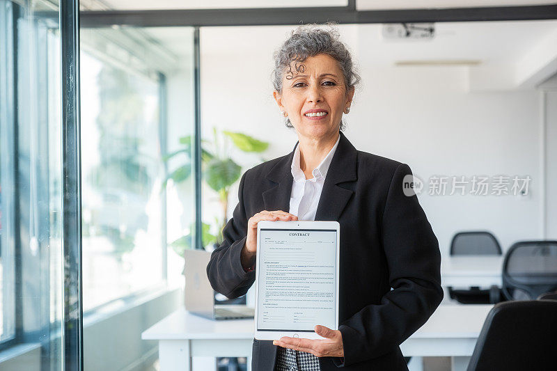 白发苍苍的高级女性正在展示电子平板电脑的合同