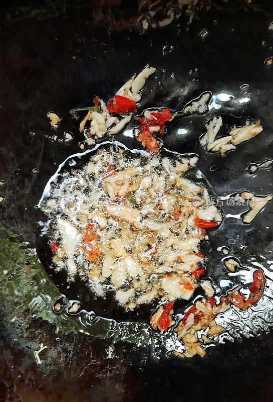 用平底锅煎蒜末和辣椒末。