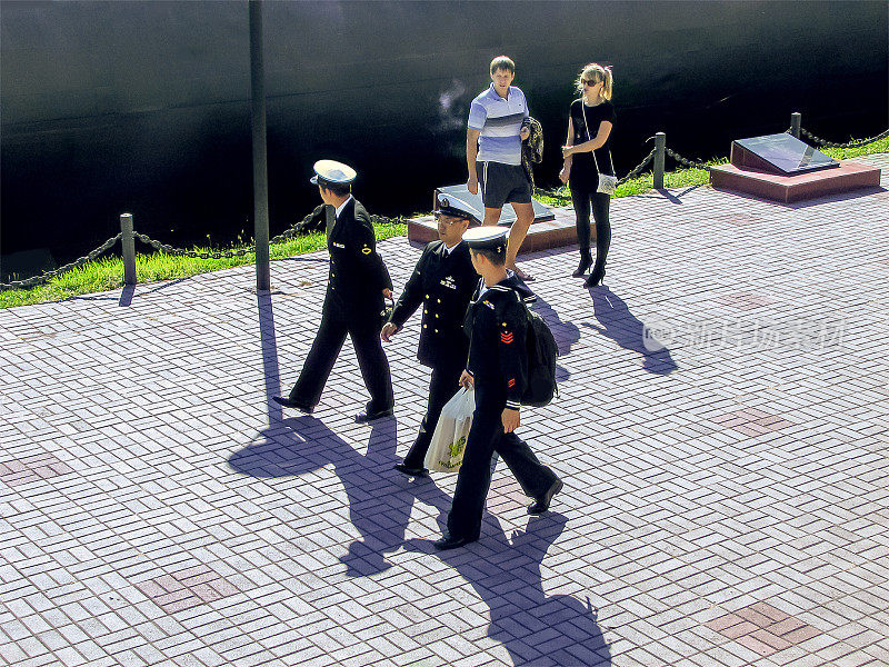 身着制服的日本海军军官沿着海参崴中心的河堤行走