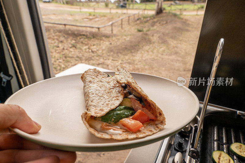 年轻女子拿着一盘素食卷