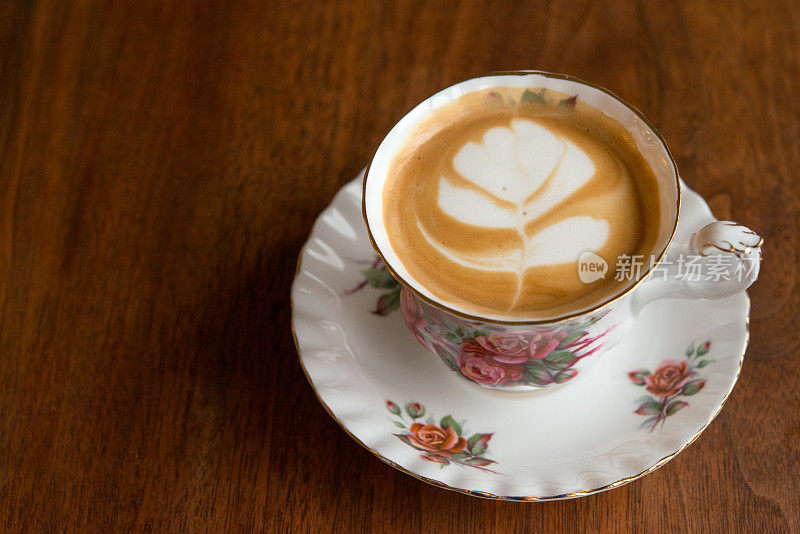 家庭咖啡师-自制纯白咖啡与脱脂牛奶在古董骨瓷杯古董胡桃木桌子