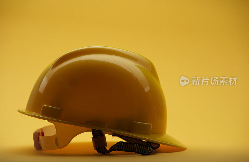 黄色背景上的黄色施工头盔
