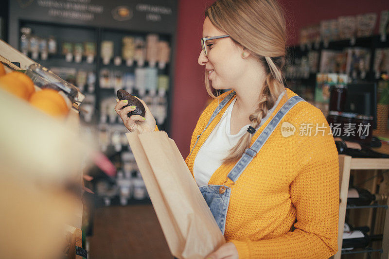 一个美丽的千禧一代女性在有机食品店。